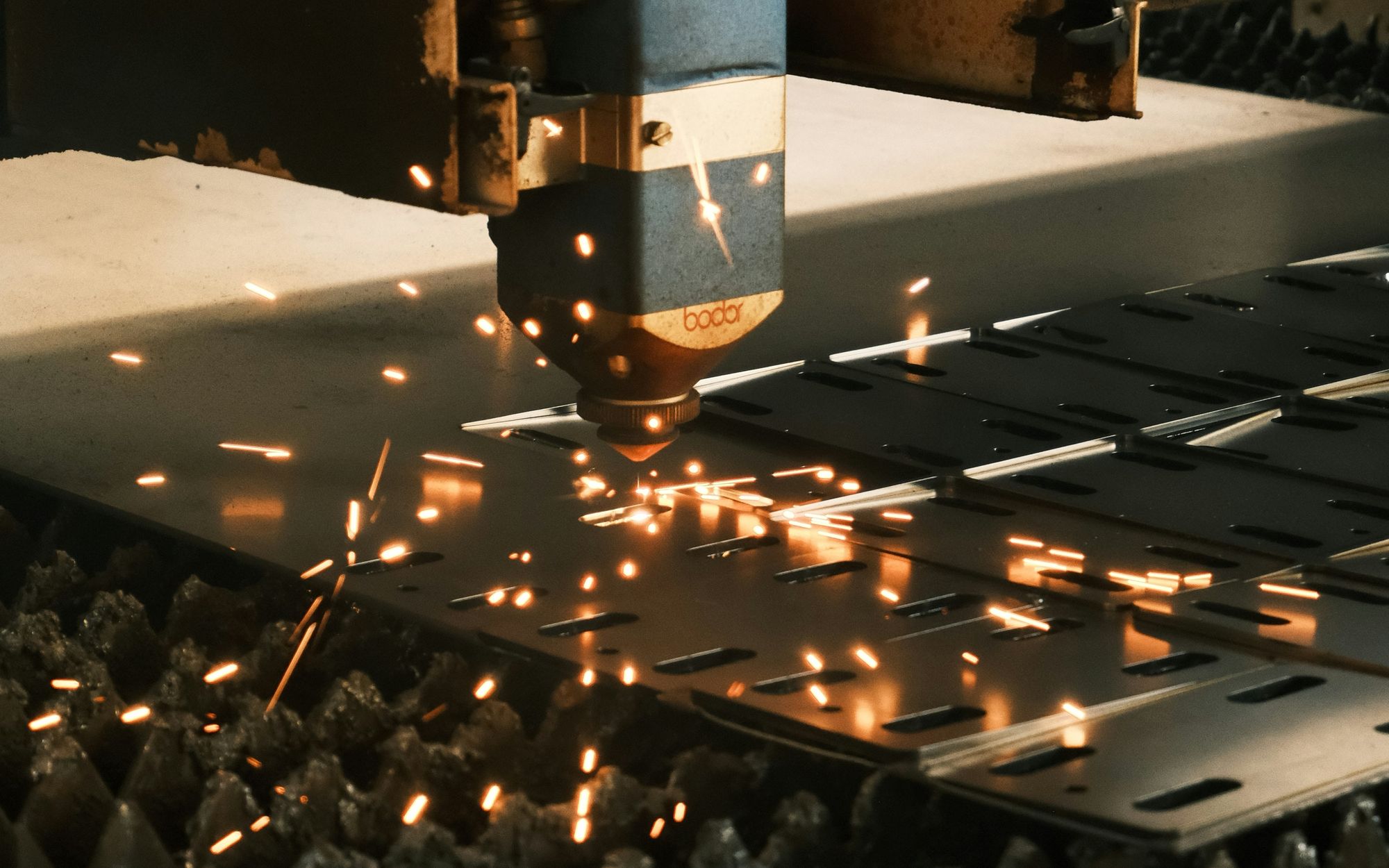 Industrial laser cutter processing perforated metal sheet